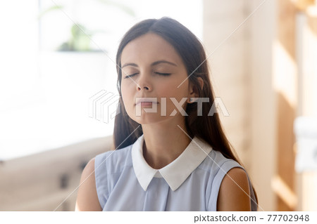 Calm young woman meditate breathe fresh air Calm young woman meditate breathe fresh air 77702948