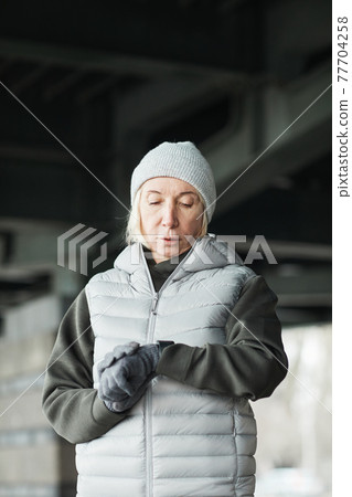 Senior woman checking pulse on tracker Senior woman checking pulse on tracker 77704258