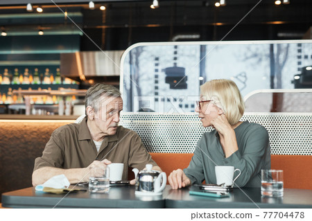 Mature friends drinking tea in cafe Mature friends drinking tea in cafe 77704478