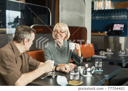 Senior couple chatting in cafe Senior couple chatting in cafe 77704481
