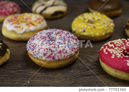 Multiple delicious donuts on table close up shot Multiple delicious donuts on table close up shot 77705360