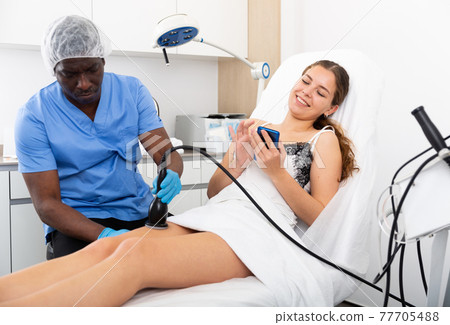 Cosmetologist reducing cellulite on the hips of a female patient Cosmetologist reducing cellulite on the hips of a female patient 77705488