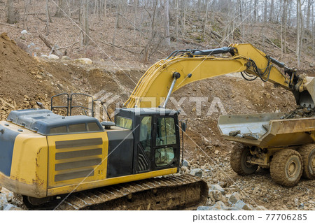 Dump trucks transporting for processing stone a tractor loads with stone 77706285