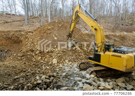 Excavator front loader with a bucket filled with crushed stone 77706286