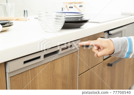 At hand pressing the switch of the dishwasher At hand pressing the switch of the dishwasher 77708540
