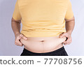 Fat man holding excessive fat belly isolated grey background. 77708756