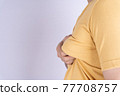 Fat man holding excessive fat boobs isolated grey background. 77708757