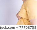 Fat man holding excessive fat boobs isolated grey background. 77708758