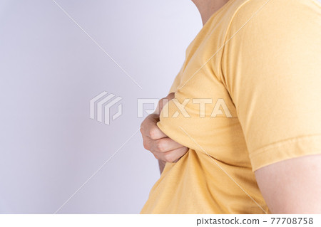 Fat man holding excessive fat boobs isolated grey background. Fat man holding excessive fat boobs isolated grey background. 77708758