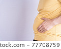 Fat man holding excessive fat belly isolated grey background. 77708759