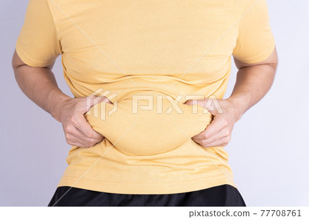 Fat man holding excessive fat belly isolated grey background. 77708761