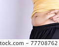 Fat man holding excessive fat belly isolated grey background. 77708762
