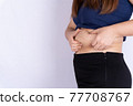 Fat woman holding excessive fat belly isolated grey background. 77708767