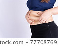 Fat woman holding excessive fat belly isolated grey background. 77708769