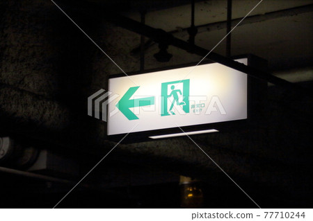 昏暗的多層停車場的疏散引導標誌 77710244