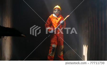 Firefighter fighting with flame using fire hose chemical water foam spray engine. Fireman wear hard hat, body safe suit uniform for protection. Rescue training in fire fighting extinguisher 77711730