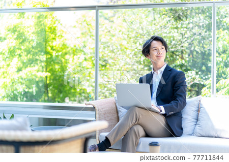 A man teleworking on the terrace. Shooting cooperation "+ SHIFT NOGIZAKA" 77711844