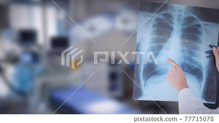 Mid section of doctor examining x-ray report against operation theatre in background Mid section of doctor examining x-ray report against operation theatre in background 77715078