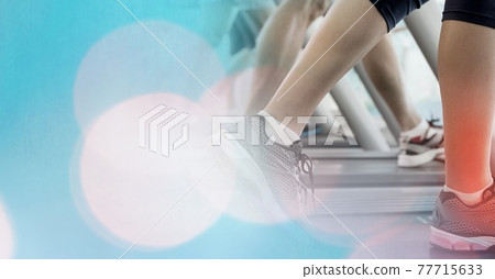 Composition of woman running on treadmill with red spot on calf showing injury over spots of light 77715633