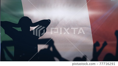 Silhouettes of sports supporters at sports event over italian flag 77716291