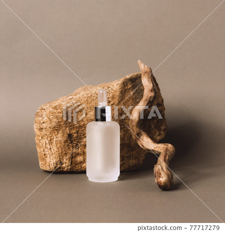 A bottle gel serum of a cosmetic product on the podium made of natural materials 77717279