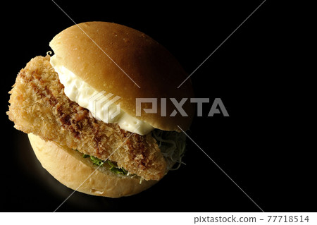 夾在大量塔塔醬和炸白魚之間的漢堡在黑色背景下拍攝（俯視圖） 77718514