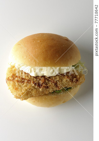 A hamburger sandwiched between plenty of tartar sauce and fried white fish is photographed on a white background (front, bird's-eye view) A hamburger sandwiched between plenty of tartar sauce and fried white fish is photographed on a white background (front, bird's-eye view) 77718642