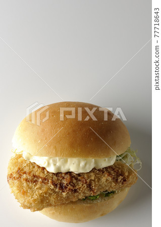 A hamburger sandwiched between plenty of tartar sauce and fried white fish is photographed on a white background (front, bird's-eye view) A hamburger sandwiched between plenty of tartar sauce and fried white fish is photographed on a white background (front, bird's-eye view) 77718643