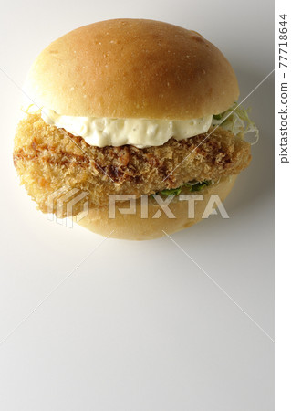 A hamburger sandwiched between plenty of tartar sauce and fried white fish is photographed on a white background (front, bird's-eye view) A hamburger sandwiched between plenty of tartar sauce and fried white fish is photographed on a white background (front, bird's-eye view) 77718644