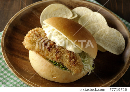 大量的塔塔醬、炸白魚三明治和薯片，放在餐墊上的木盤上 77719726