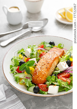 Salmon fish salad. Fresh vegetable greek salad with tomato, pepper, lettuce, olives, cucumbers, feta cheese and grilled salmon fish fillet in bowl, healthy food, omega 3, keto diet, mediterranean Salmon fish salad. Fresh vegetable greek salad with tomato, pepper, lettuce, olives, cucumbers, feta cheese and grilled salmon fish fillet in bowl, healthy food, omega 3, keto diet, mediterranean 77722067
