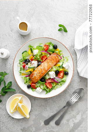 Salmon fish salad. Fresh vegetable greek salad with tomato, pepper, lettuce, olives, cucumbers, feta cheese and grilled salmon fish fillet in bowl, healthy food, omega 3, keto diet, mediterranean Salmon fish salad. Fresh vegetable greek salad with tomato, pepper, lettuce, olives, cucumbers, feta cheese and grilled salmon fish fillet in bowl, healthy food, omega 3, keto diet, mediterranean 77722068