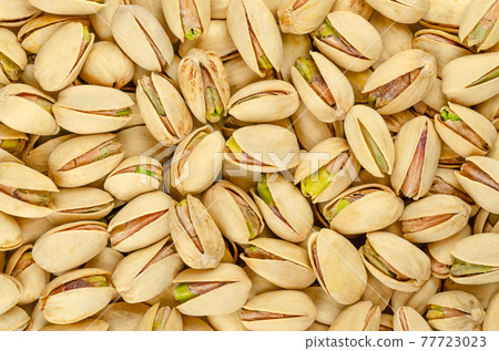 Roasted and salted pistachio seeds with shell, background, from above. Snack food, made from fruits of Pistacia vera. Green kernels in light yellow shells, ready to eat. Backdrop. Macro food photo. Roasted and salted pistachio seeds with shell, background, from above. Snack food, made from fruits of Pistacia vera. Green kernels in light yellow shells, ready to eat. Backdrop. Macro food photo. 77723023