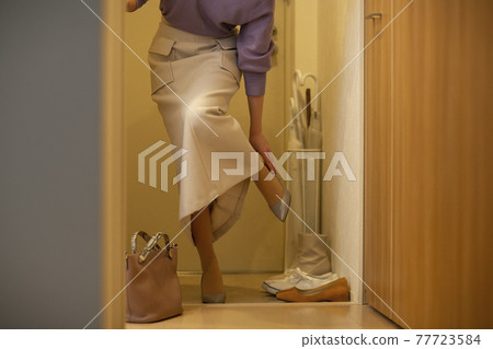 A woman who goes home and takes off her shoes at the entrance 77723584