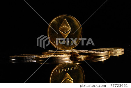 Closeup golden coin with Ether logo. New cryptocurrency Ethereum ETH 2.0 on a top of bitcoin coins against black background. A heap of decentralized digital currency. Crypto payment. Electronic money Closeup golden coin with Ether logo. New cryptocurrency Ethereum ETH 2.0 on a top of bitcoin coins against black background. A heap of decentralized digital currency. Crypto payment. Electronic money 77723661