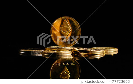 Closeup golden coin with Ether logo. New cryptocurrency Ethereum ETH 2.0 on a top of bitcoin coins against black background. A heap of decentralized digital currency. Crypto payment. Electronic money Closeup golden coin with Ether logo. New cryptocurrency Ethereum ETH 2.0 on a top of bitcoin coins against black background. A heap of decentralized digital currency. Crypto payment. Electronic money 77723663