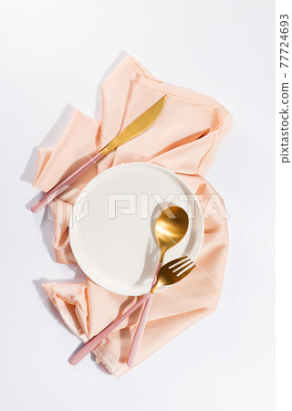 Beautifully decorated table with white plates, golden apple cutlery on luxurious beige tablecloths Beautifully decorated table with white plates, golden apple cutlery on luxurious beige tablecloths 77724693