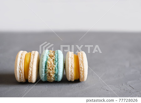 macaroons in pastel blue and beige colors on grey background. french sweet dessert made of almond flour. homemade macaron 77728026
