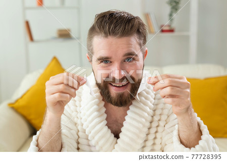 Bearded man removing eye patches on his face. Wrinkles and face home care for men. Bearded man removing eye patches on his face. Wrinkles and face home care for men. 77728395