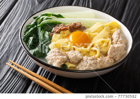 Delicious Asian homemade noodle soup with fried anchovies, meatballs and bok choy close-up in a bowl. horizontal Delicious Asian homemade noodle soup with fried anchovies, meatballs and bok choy close-up in a bowl. horizontal 77730582