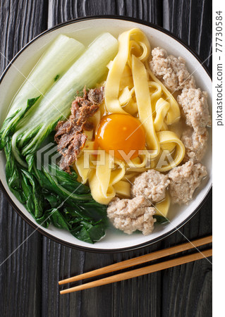 Ban Mian Minced Pork Noodle Soup Handmade closeup in the bowl. Vertical top view Ban Mian Minced Pork Noodle Soup Handmade closeup in the bowl. Vertical top view 77730584