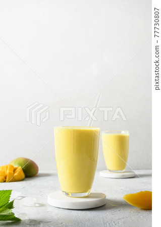 Indian mango or turmeric lassi on gray background 77730807