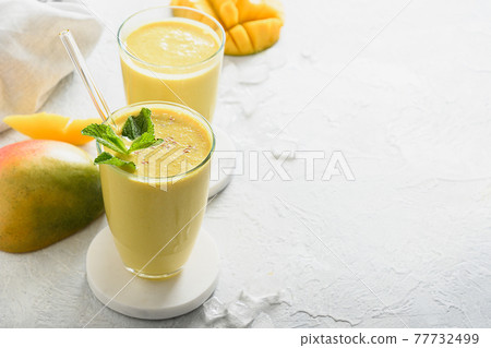 Indian mango or turmeric lassi on gray background Indian mango or turmeric lassi on gray background 77732499