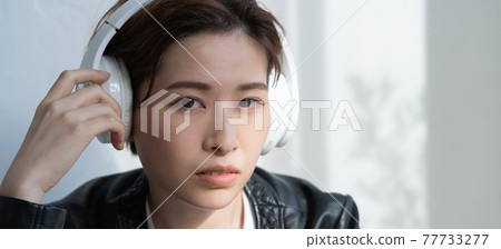 身穿皮夾克、戴著耳機聽音樂的無性別 LGBT 女性橫幅尺寸 77733277