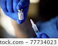 Doctor preparing injection with covid-19 vaccine at hospital 77734023