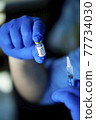 Doctor preparing injection with covid-19 vaccine at hospital 77734030