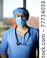 Confidence young male surgeon with face mask looking at camera 77734038