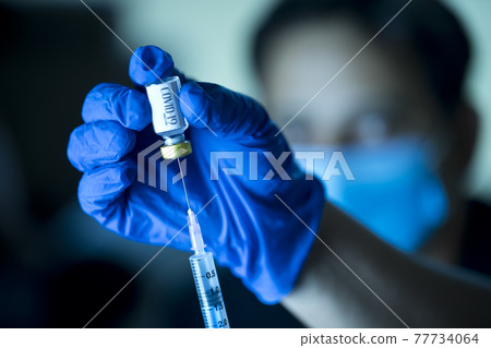 Doctor pulling vaccine liquid from vial to vaccinate man Doctor pulling vaccine liquid from vial to vaccinate man 77734064