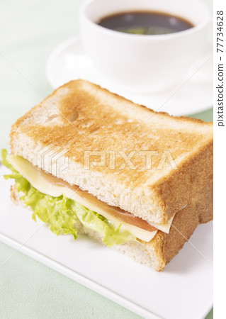 早餐生火腿奶酪三明治和熱咖啡 早餐生火腿奶酪三明治和熱咖啡 77734628