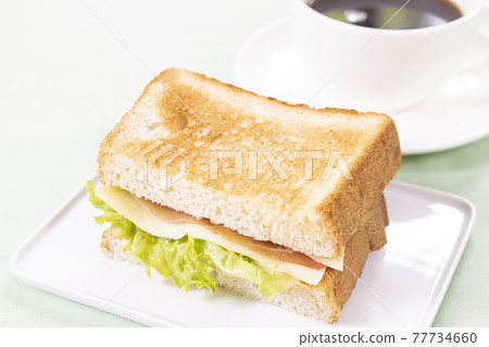 早餐生火腿奶酪三明治和熱咖啡 早餐生火腿奶酪三明治和熱咖啡 77734660